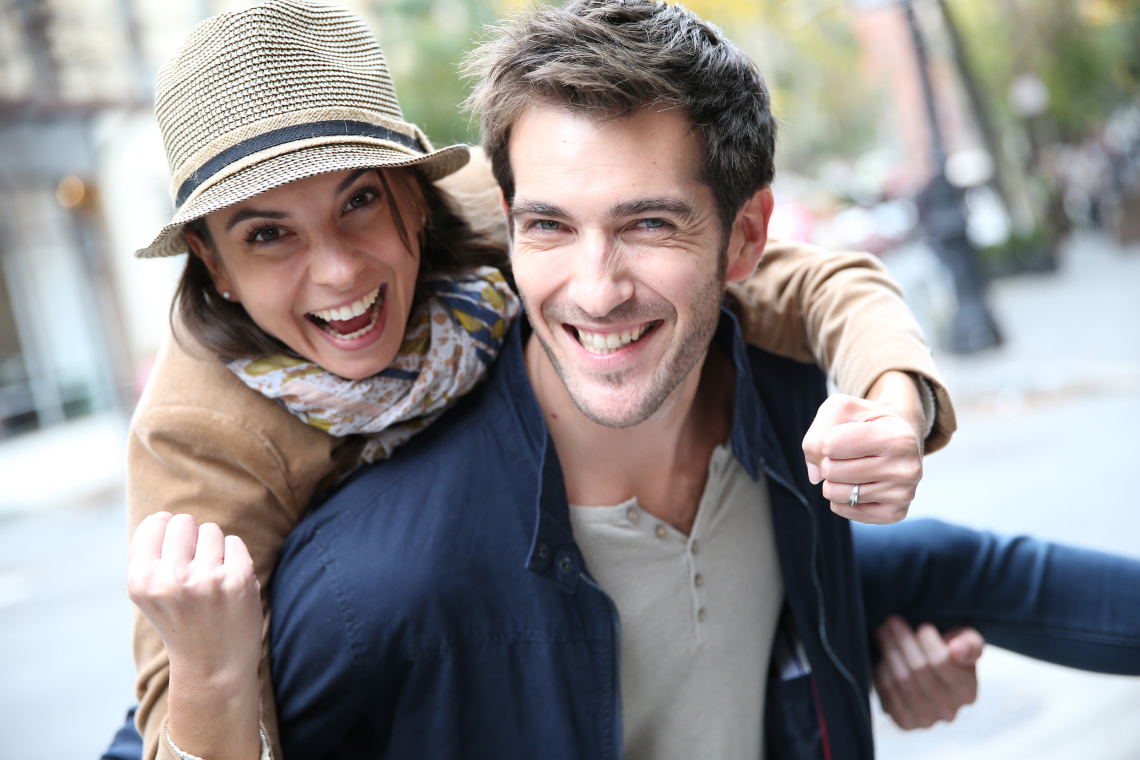 A dentist examining a young adult patient holding their cheek in discomfort inside a modern dental clinic.